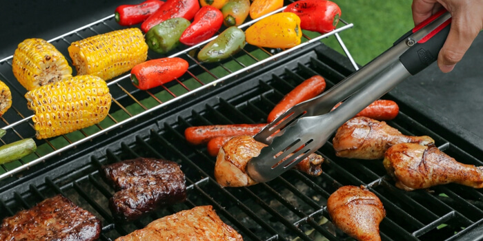 A deliciously grilled fish surrounded by top-notch BBQ tools and accessories.